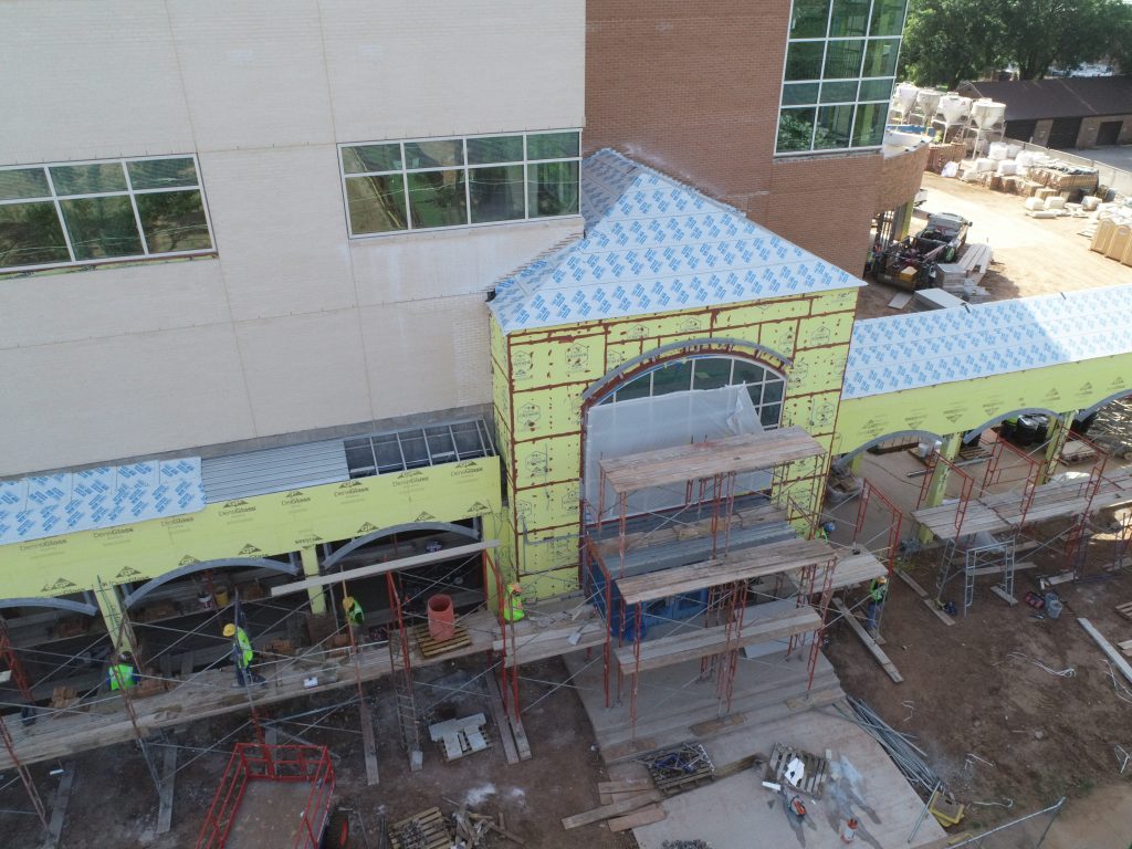 Crews work on the exterior of the building to prepare for students in late August.