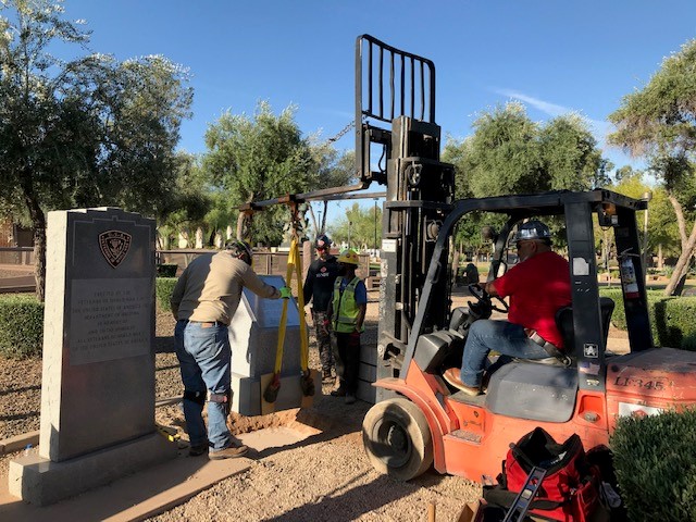 Sundt employee-owners install one of two granite pedestals.
