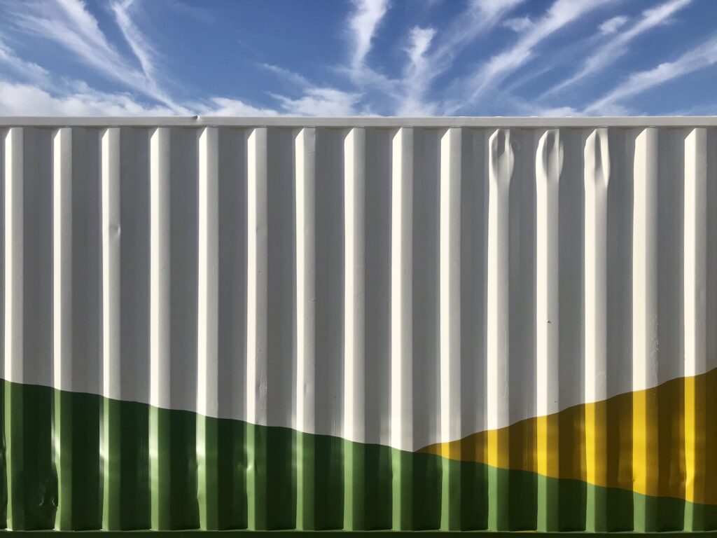 close up of exterior of shipping container painted green and yellow for sustainability