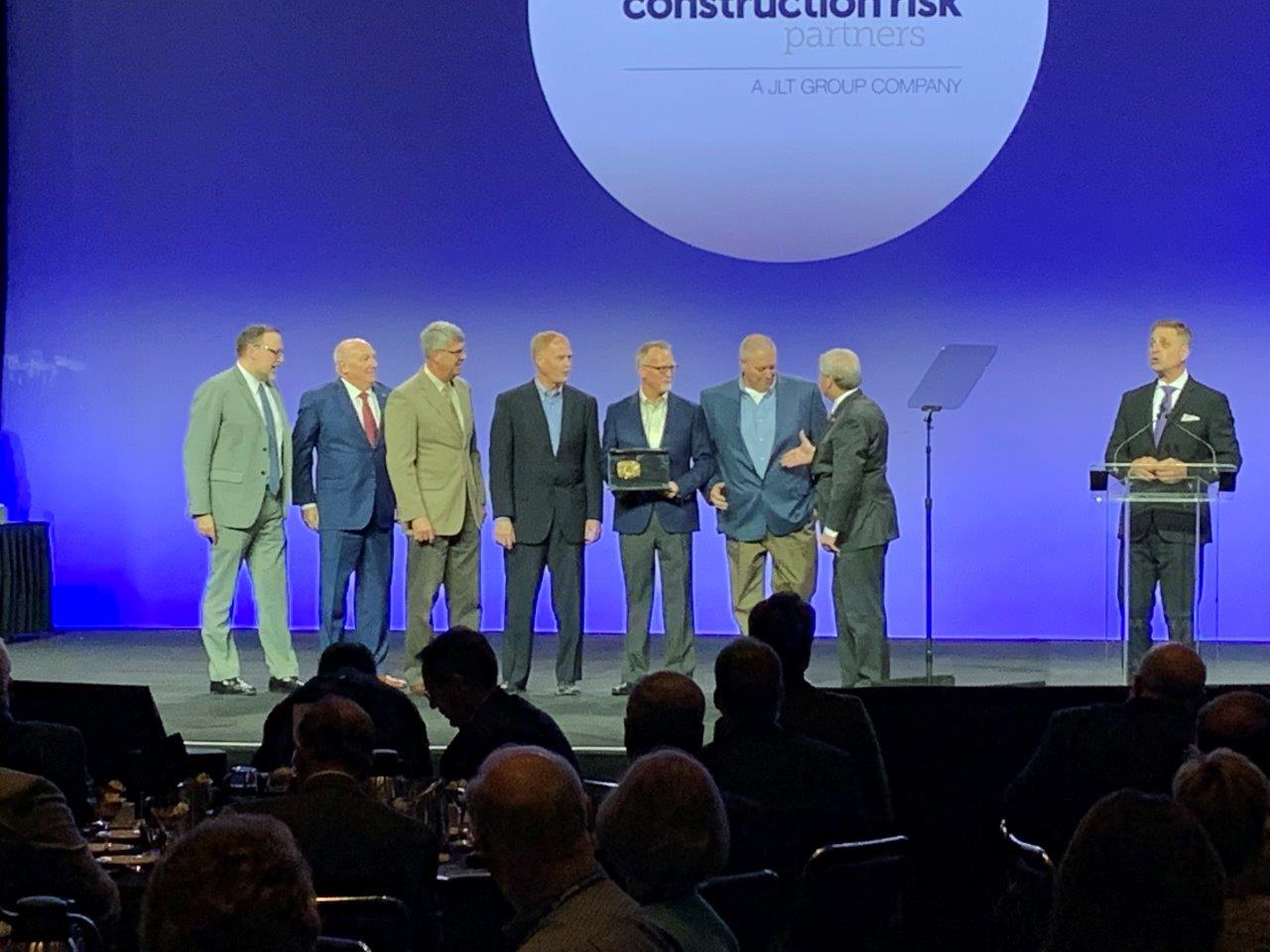 APS Senior Project Manager Dewayne Keegel (third from left) joins Sundt employee-owners Ken Dean, Steve Roberts and Derek Neill in accepting the 2019 JLT Build America Award.