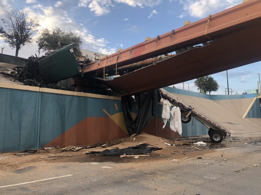 The semi-truck lost control and drove up the embankment, crashed into the bridge, and caught fire immediately.