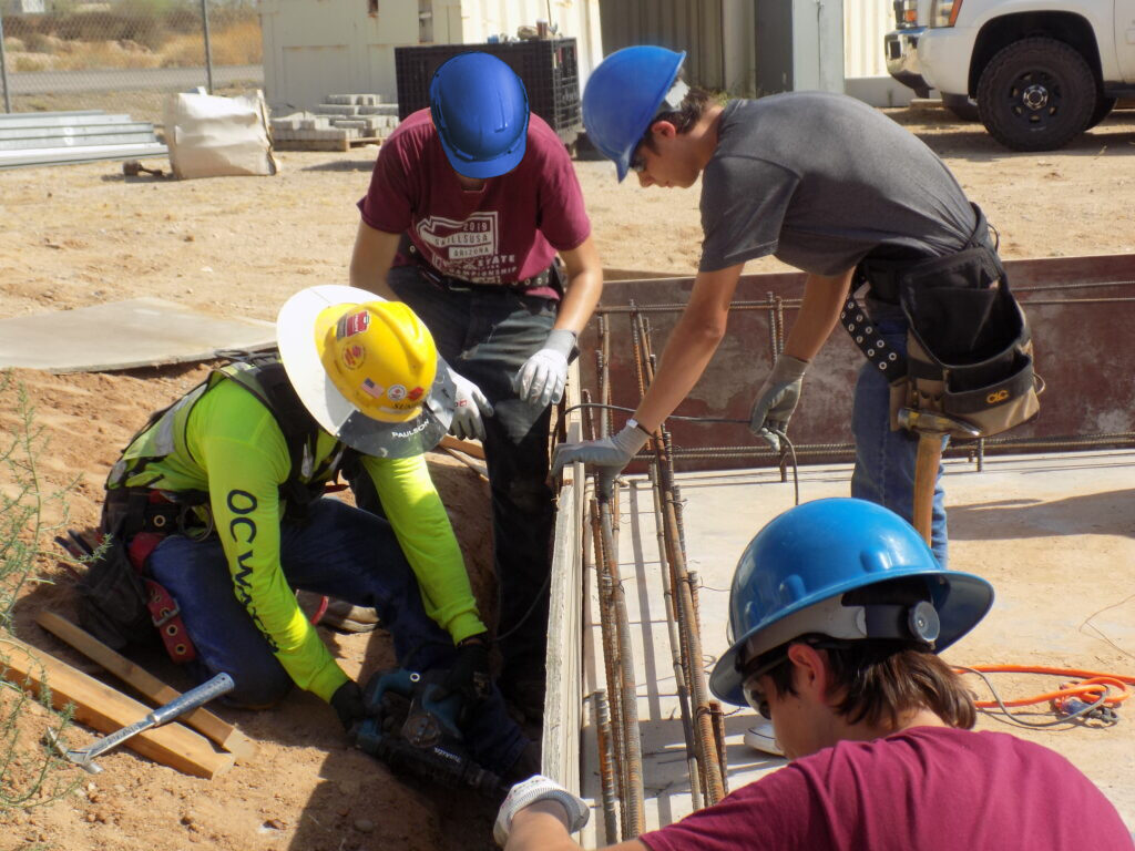 Sundt carpenter shows high school students how to prepare a wall for concrete