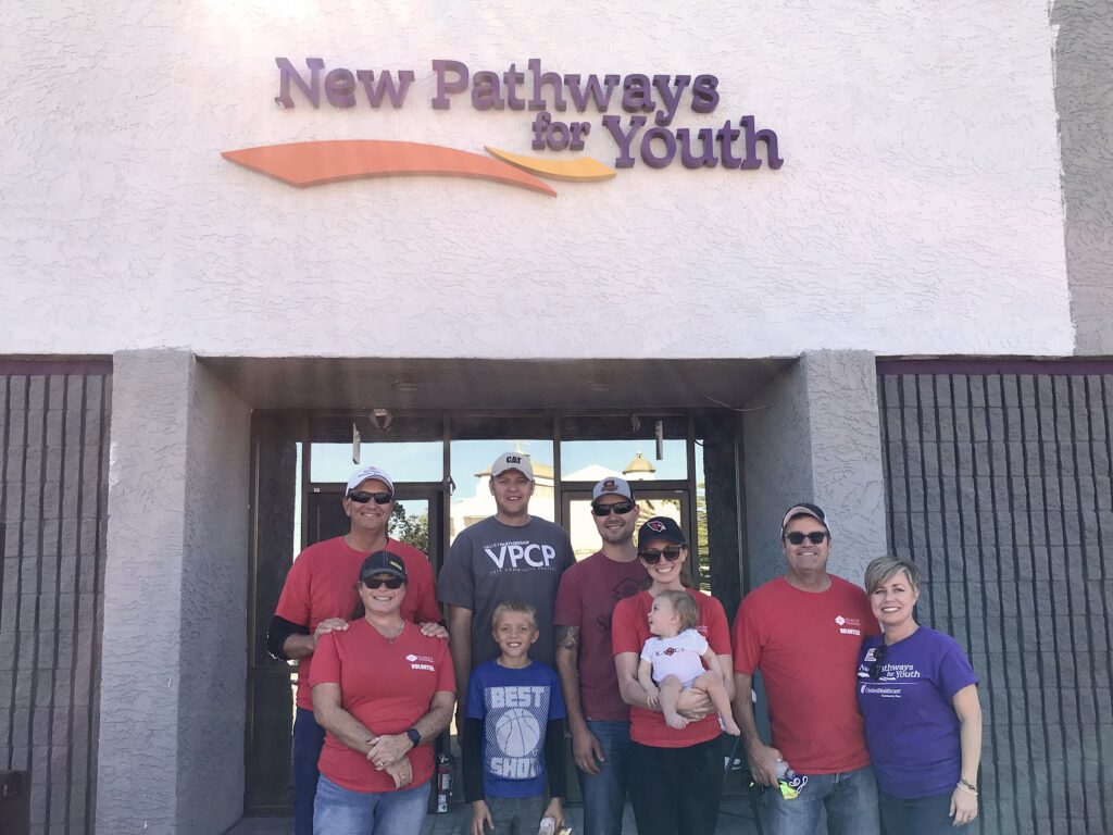 Sundt Employee-Owners and their family members standing in front of New Pathways for Youth's new building