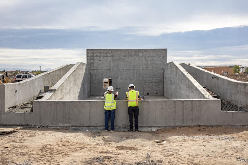 two men standing in front of wave simulator concrete frame at east side regional park