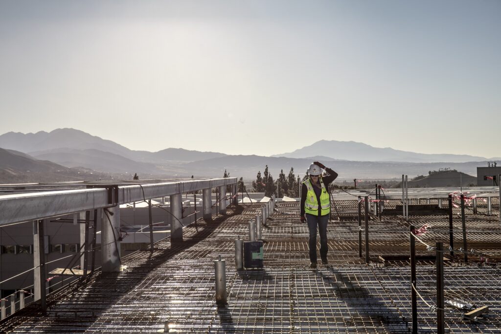 Reese realizando una inspección del techo en el proyecto del Centro para la Innovación Global en CSU San Bernardino durante un día ventoso