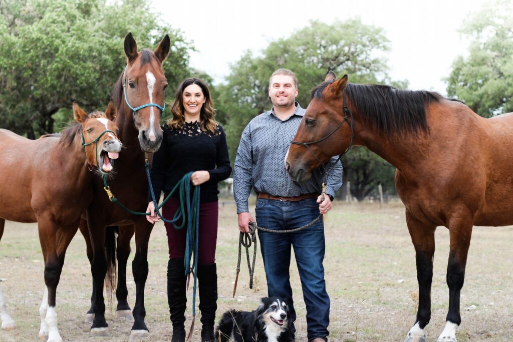 Amy and Chad Yount stand with their horses and dog