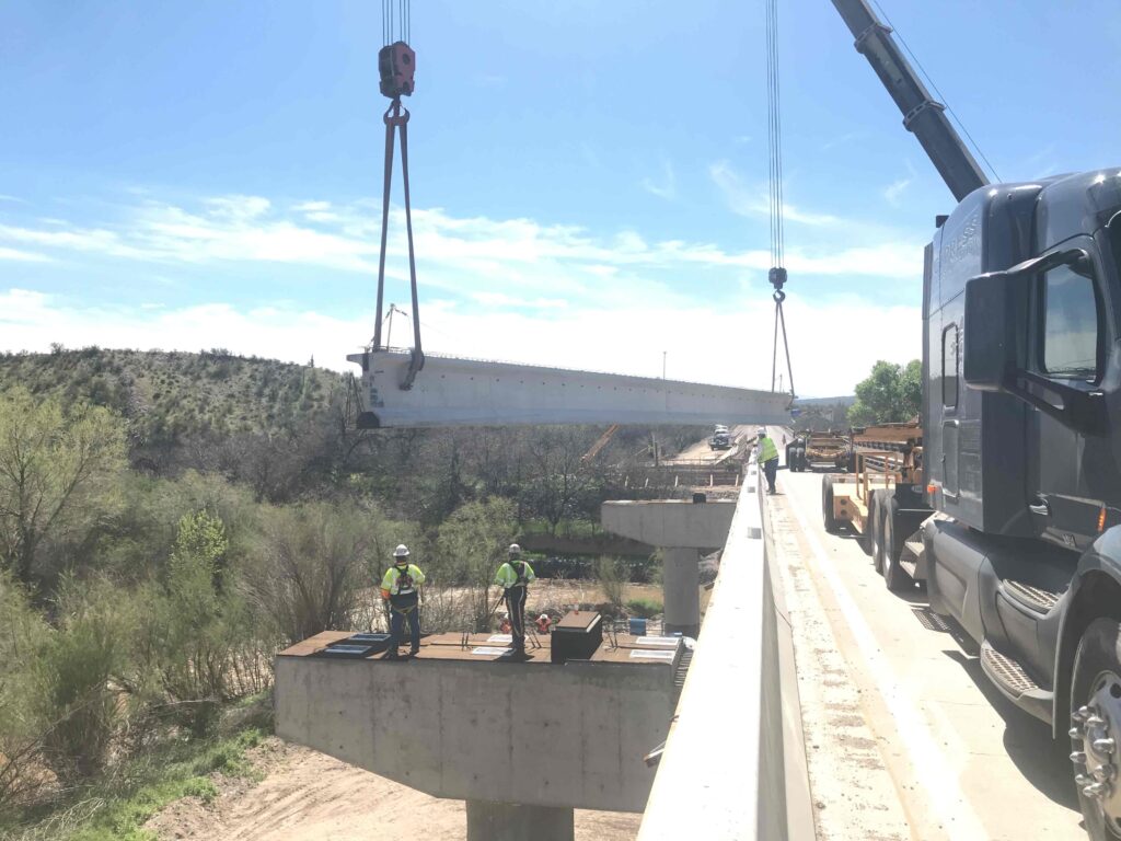 a crew sets a new bridge girder on the expanded gila river bridge
