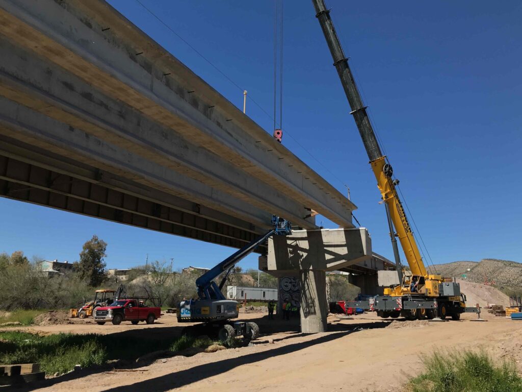 a crew sets a new bridge girder on the expanded gila river bridge