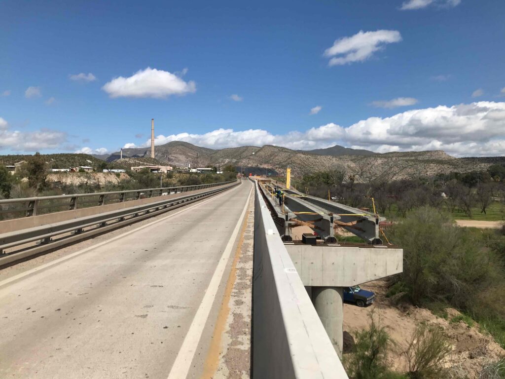 a crew sets a new bridge girder on the expanded gila river bridge