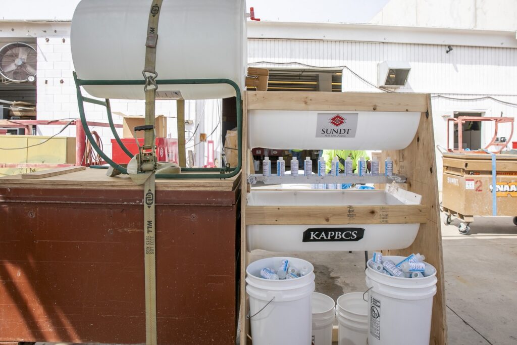 hand sanitizer drip system made of 55-gallon drum cut in half