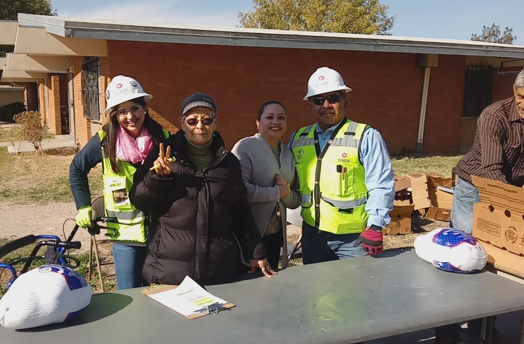 Field Engineer Gianna Aguirre (left) and Field Superintendent Lorenzo Ramos Jr. (right) work with HACEP staff to distribute donated turkeys to Sun Plaza residents