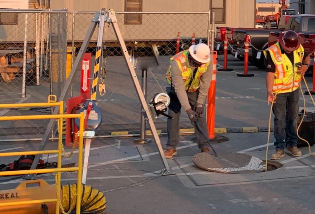 El gerente de HSE del proyecto, Chris Morales, ASP, CHST, probó la atmósfera de un espacio confinado real con una demostración usando una boca de acceso en el sitio