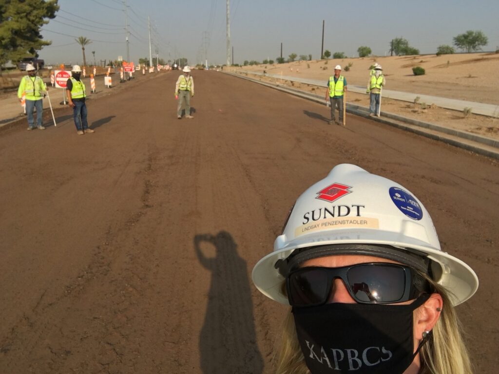 Selfie del gerente del proyecto de construcción y su equipo parados en una carretera en Arizona