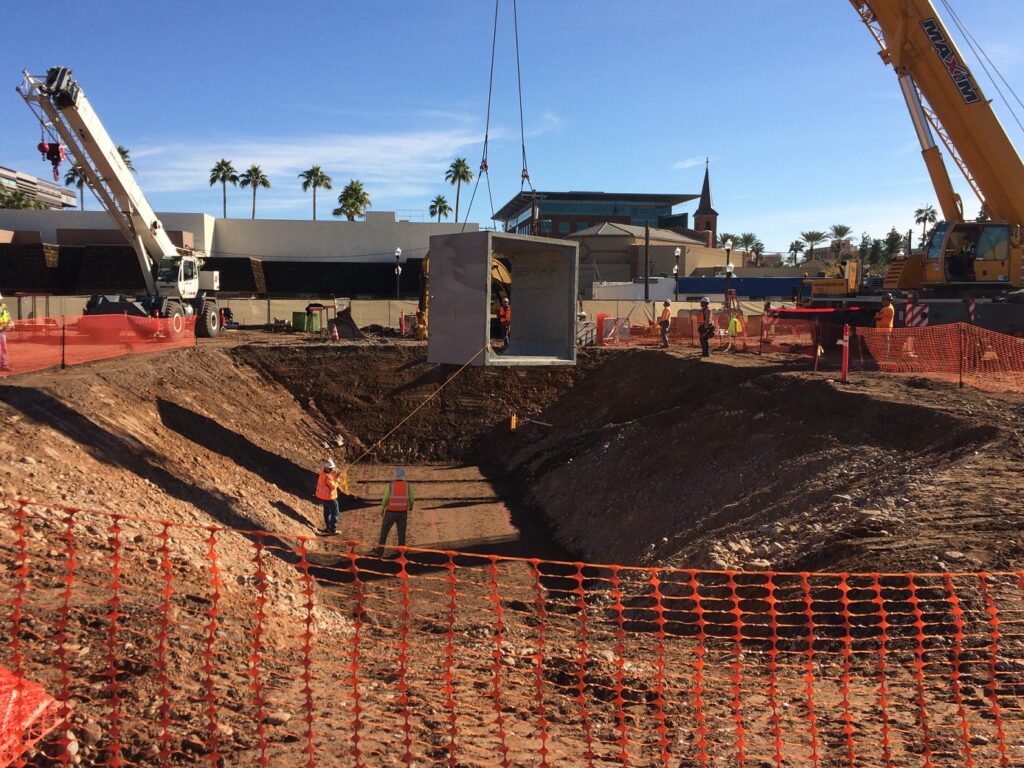 Los miembros del equipo de Sundt colocan una alcantarilla de caja de 10 por 10 pies en el proyecto de desarrollo de uso mixto residencial y minorista de Union Tempe