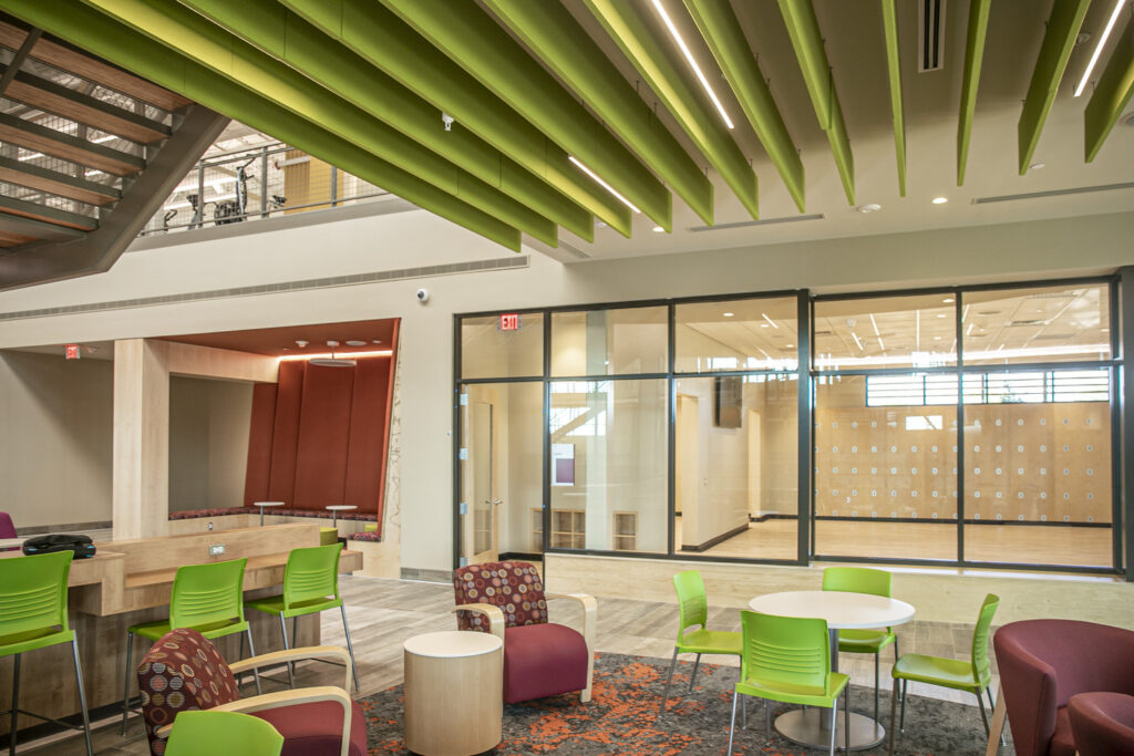 Meeting spaces and workstations are located underneath the lobby's main staircase, adjacent to the fitness studio. 