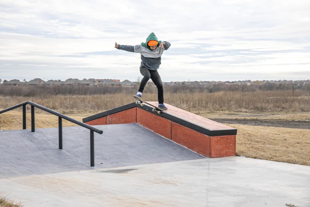 Un skater se bloquea en un deslizamiento de la parte trasera en el parque de patinaje del centro recreativo beacon de la ciudad de arlington, texas