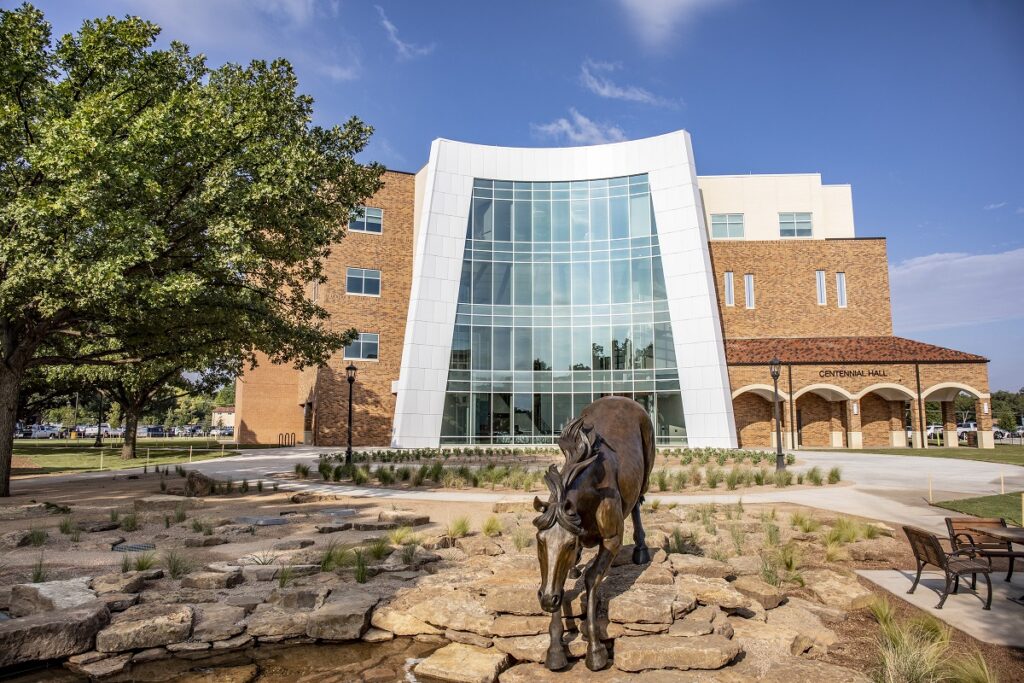 the fountain in front of Centenial Hall Health and Social Sciences Building with building entrance and large atrium in background