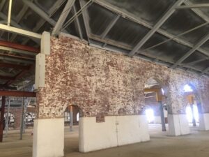 historic paint shop building interior with original brick wall and arched doorways