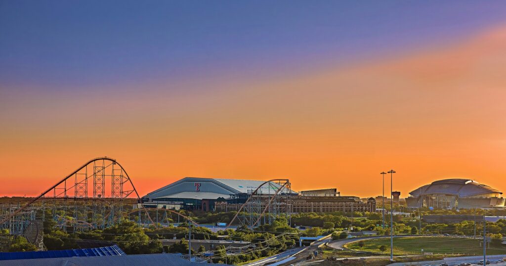 vista de la puesta de sol sobre Arlington Texas con montañas rusas de seis banderas y Texas Rangers y Dallas Cowboys' AT&T Stadium en segundo plano