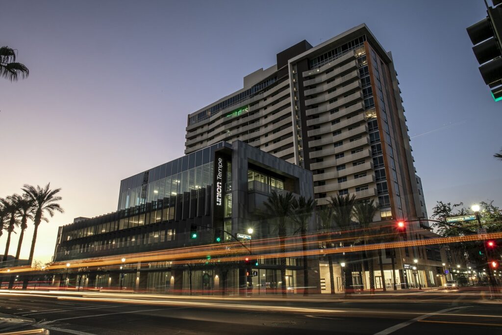 Vista nocturna de la calle de Union Tempe, desarrollo de viviendas multifamiliares de torre doble de 10 y 14 pisos en Tempe, Arizona