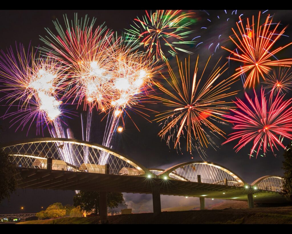 fireworks july 4th celebration over illuminated steel arches of ft worth w 7th street bridge