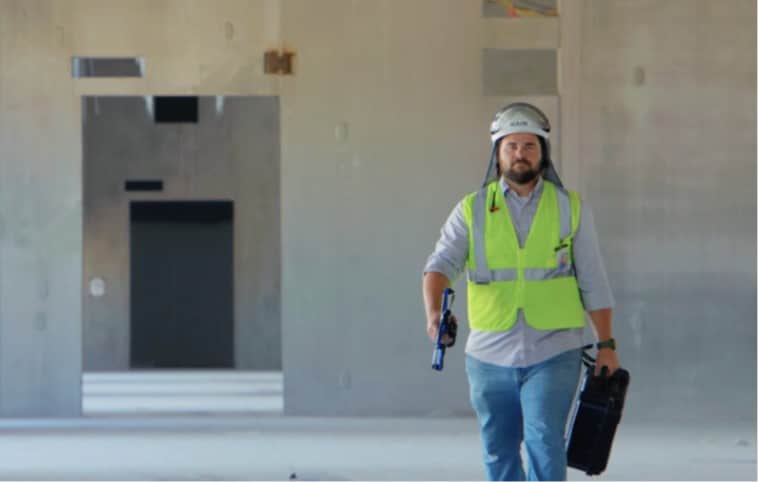 El ingeniero de construcción virtual Dean Miller lleva un drone autónomo skydio y un estuche en el sitio de construcción de un centro de datos