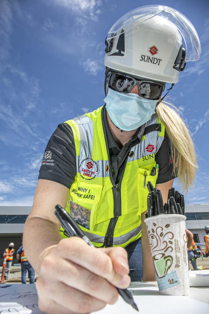 HS&E Manager Reese Fortin signing a banner at the SDIA Airport Support Facilities project last year, which earned the prestigious Cal/OSHA Voluntary Protection Program (VPP) construction designation. 