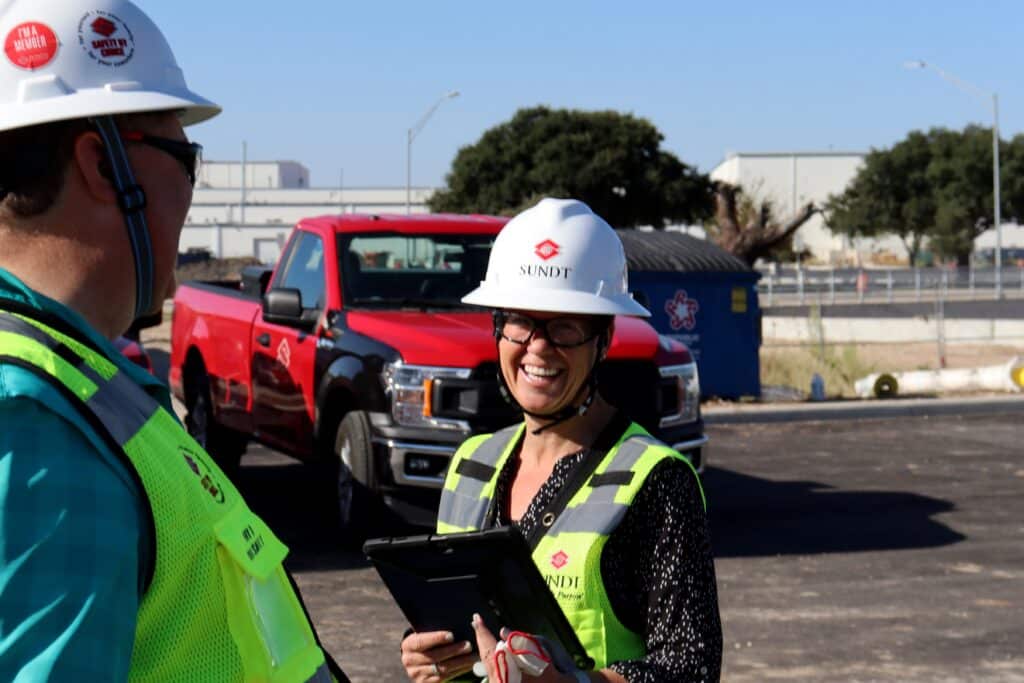 Senior Project Manager Holly Horsak discusses project progress with Building Group Vice President Bob Aniol while holding an iPad