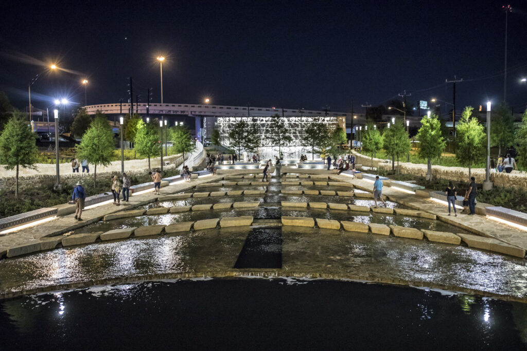 night time view of san pedro creek water fall feature with people walking in linear park