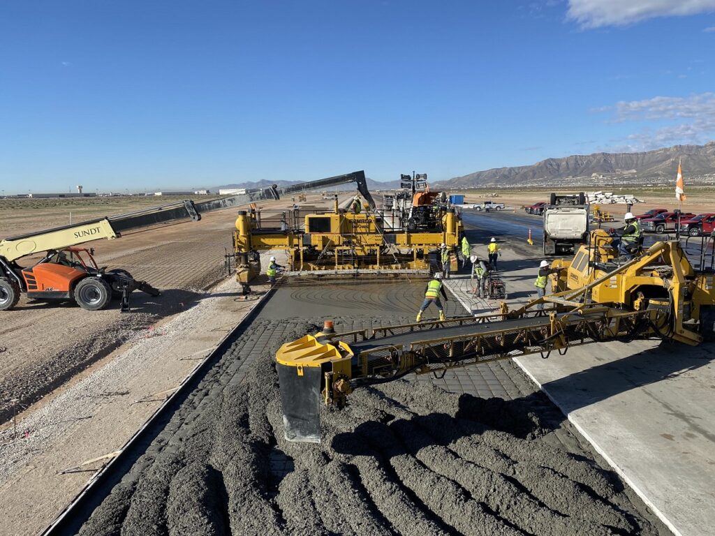 a concrete paving crew performs double strike-off paving on an airfield runway in El Paso
