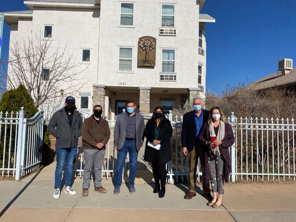 A group of people stand outside homeless shelter.