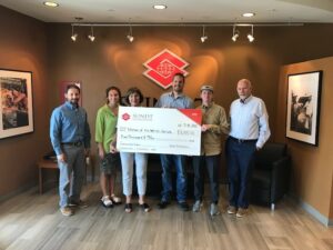 Six people standing and holding a check.