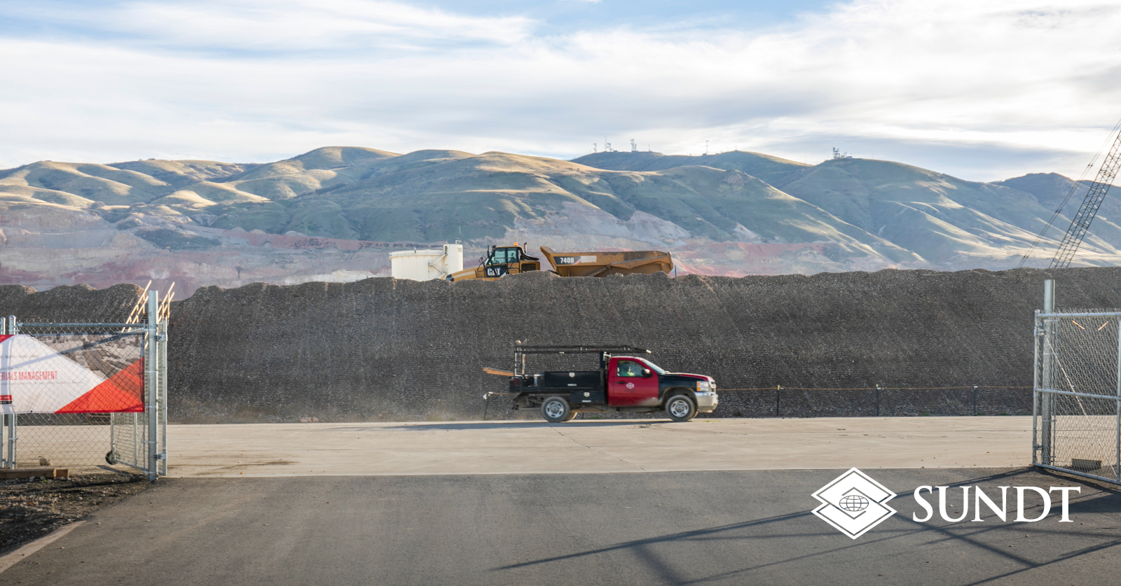 Landscape shot of mountains and a Sundt truck at a job site.