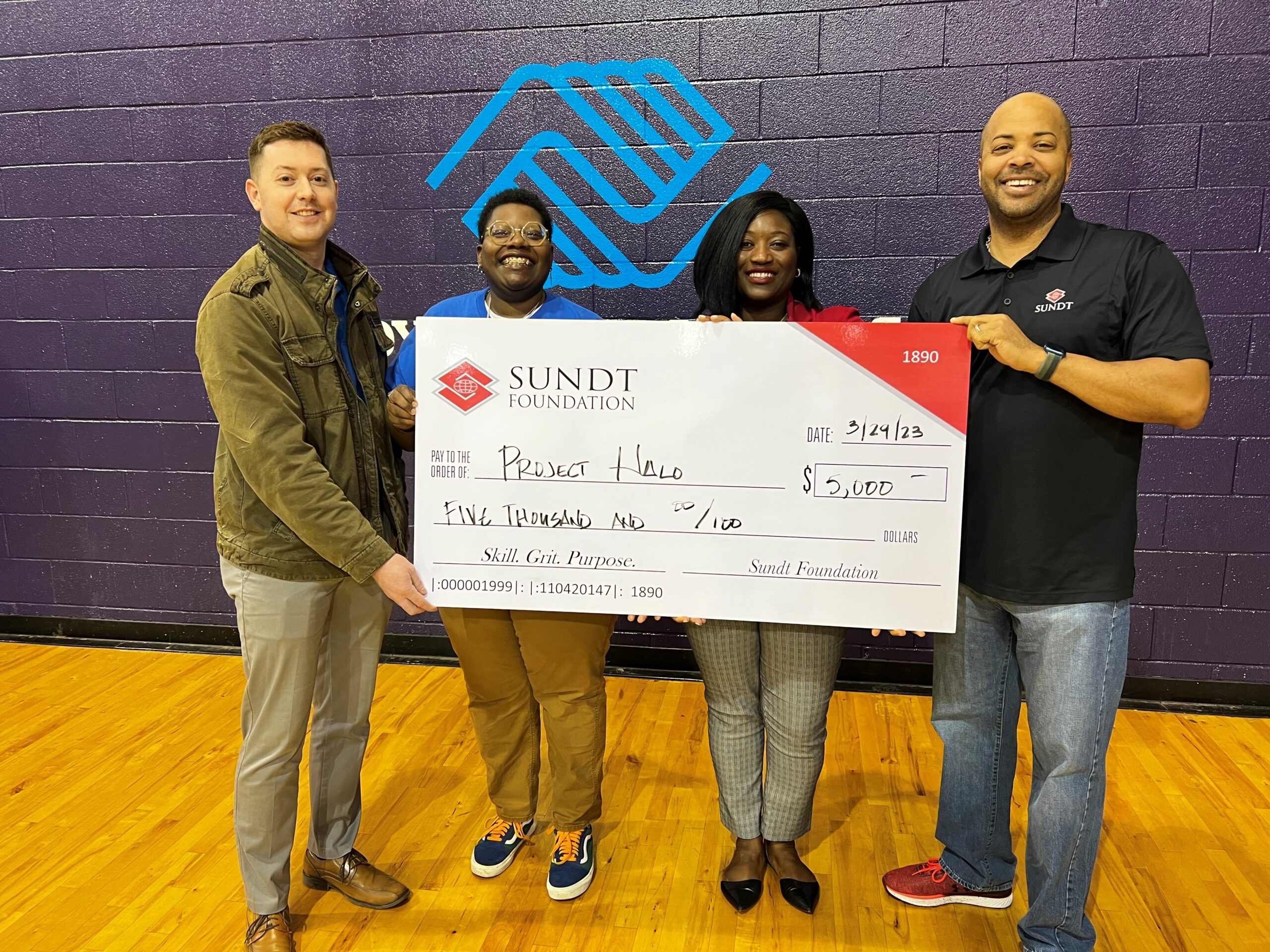 Sundt Employees hold a $5,000 check raised for Charlotte's Project Halo