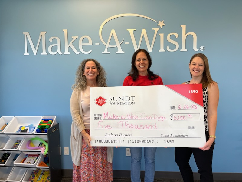 Los empleados de Sund entregan un cheque a Make-A-Wish San Diego